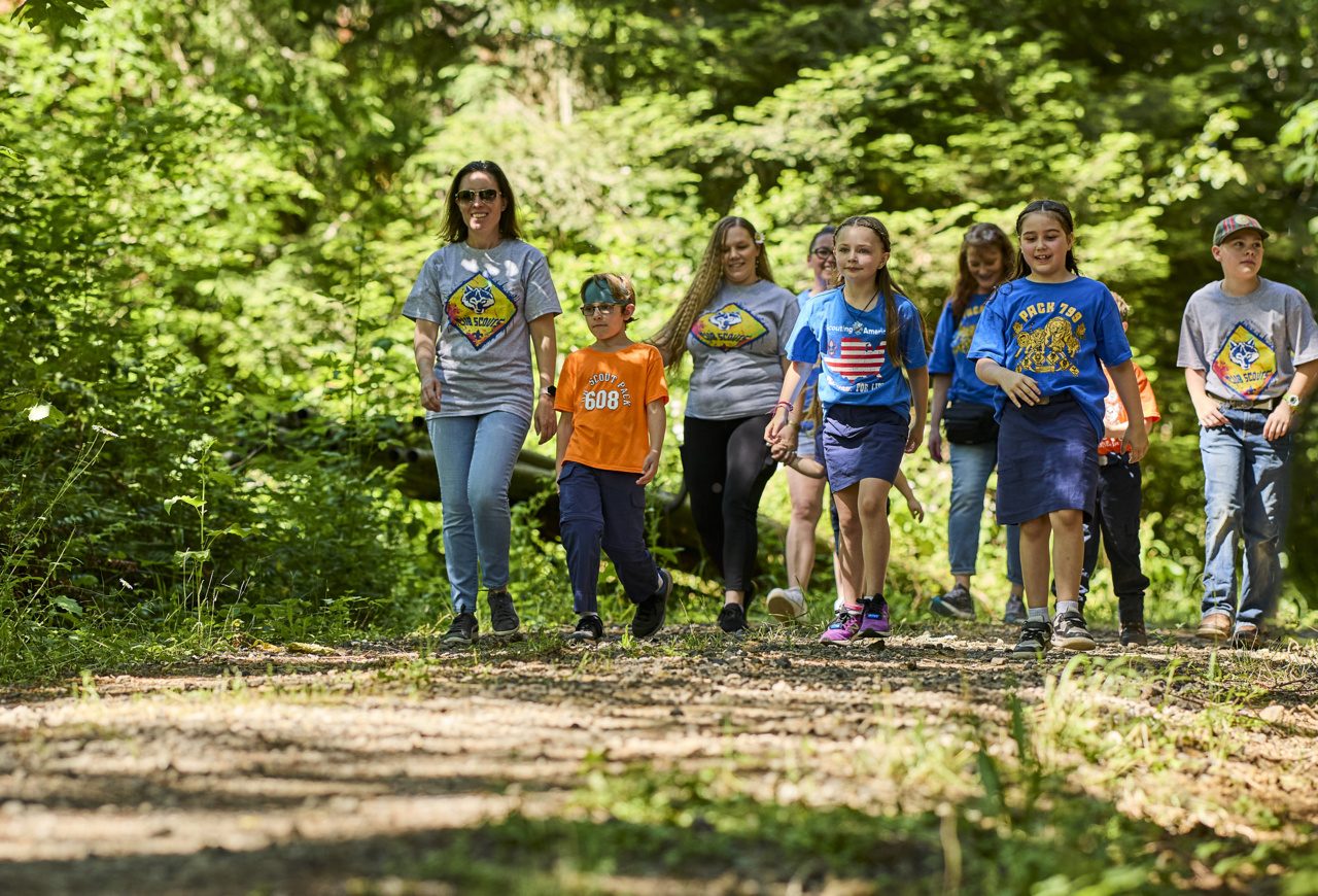 Cub Scouts and adults walking a wooded trail together